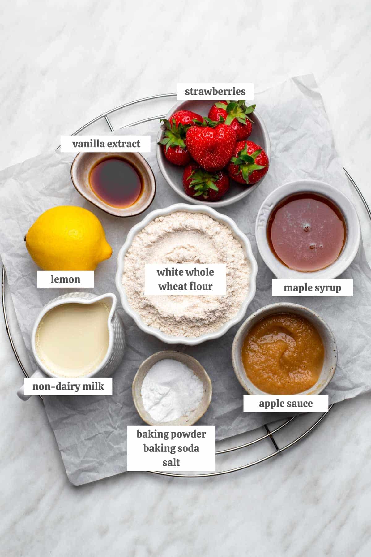 Gathered ingredients for vegan strawberry muffins measured out into individual bowls with labels.