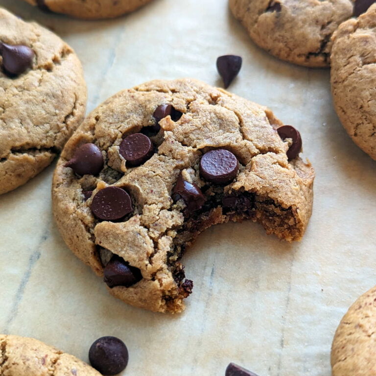 A vegan peanut butter chocolate chip cookie with a bite taken out of it.