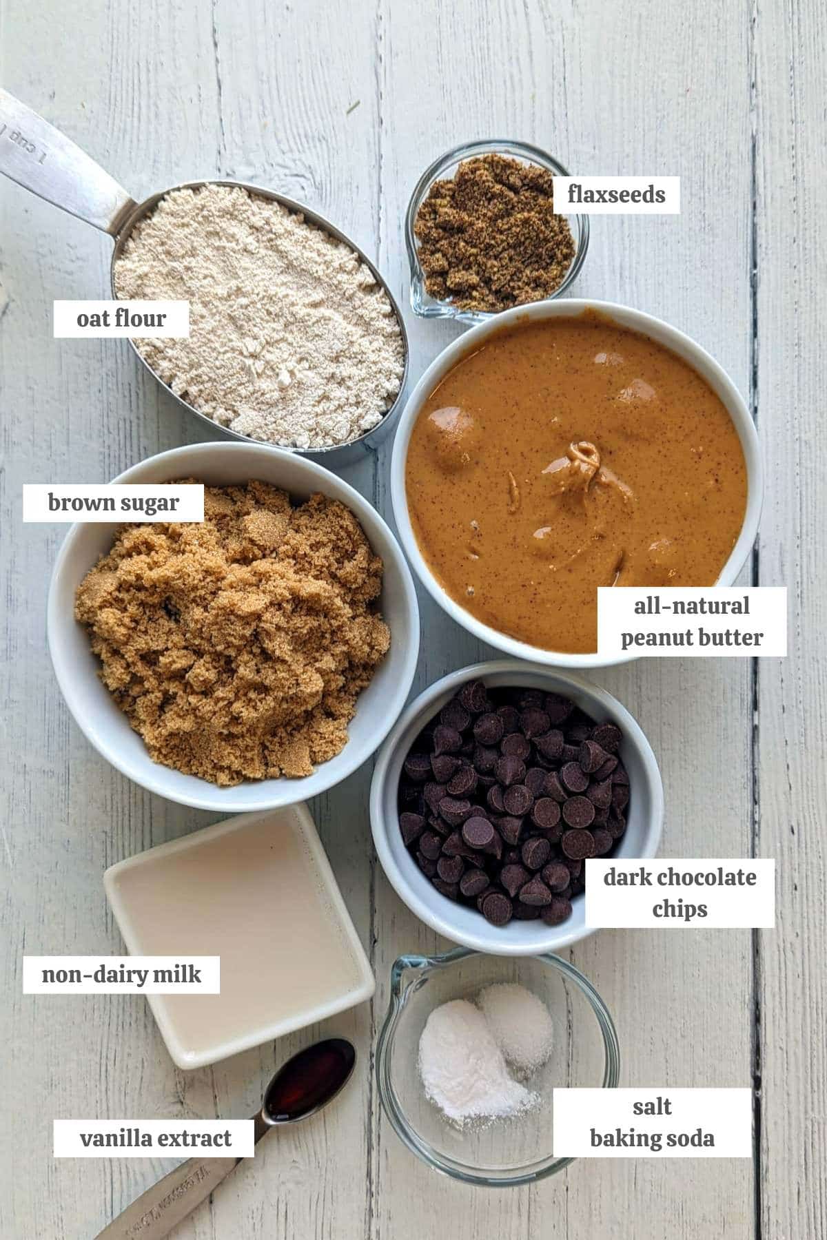 Gathered ingredients for these vegan peanut butter chocolate chip cookies measured into individual bowls with labels.