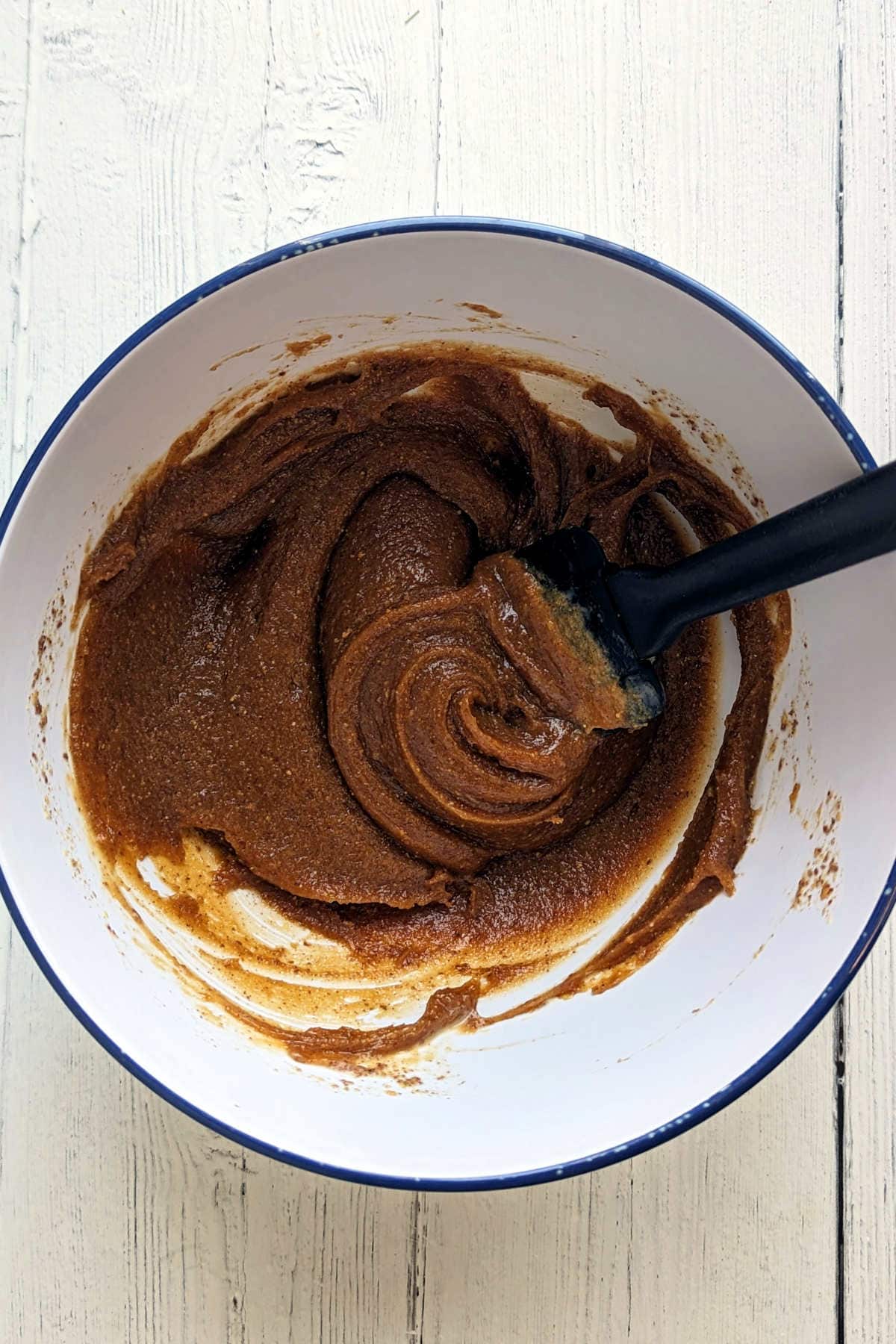 All the wet ingredients stirred into the peanut butter mixture in a mixing bowl.