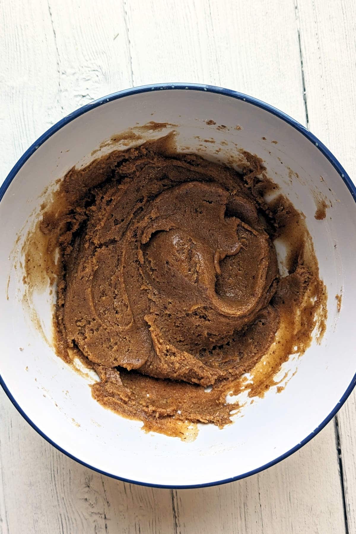 Dry ingredients mixed into the batter of vegan peanut butter chocolate chip cookies.