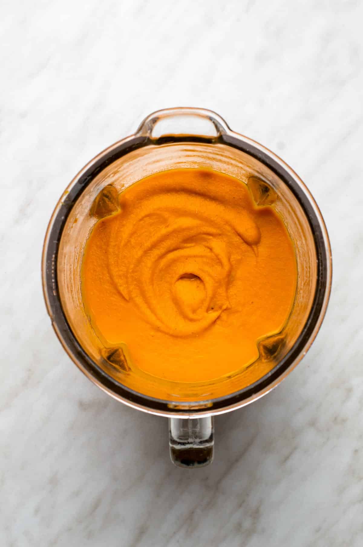 Carrot lentil soup blended in a blender pitcher.