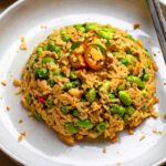 A plate of peanut butter rice with chopsticks placed next to it.