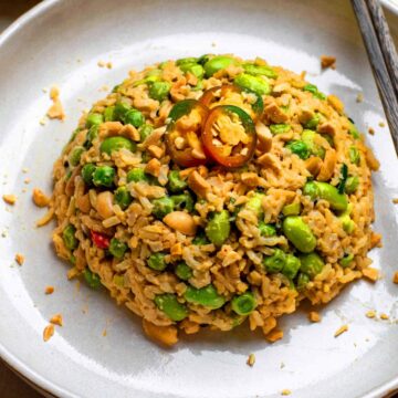A plate of peanut butter rice with chopsticks placed next to it.