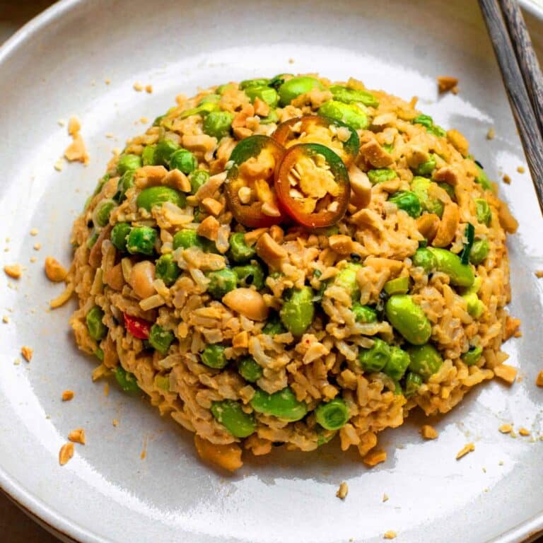 A plate of peanut butter rice with chopsticks placed next to it.