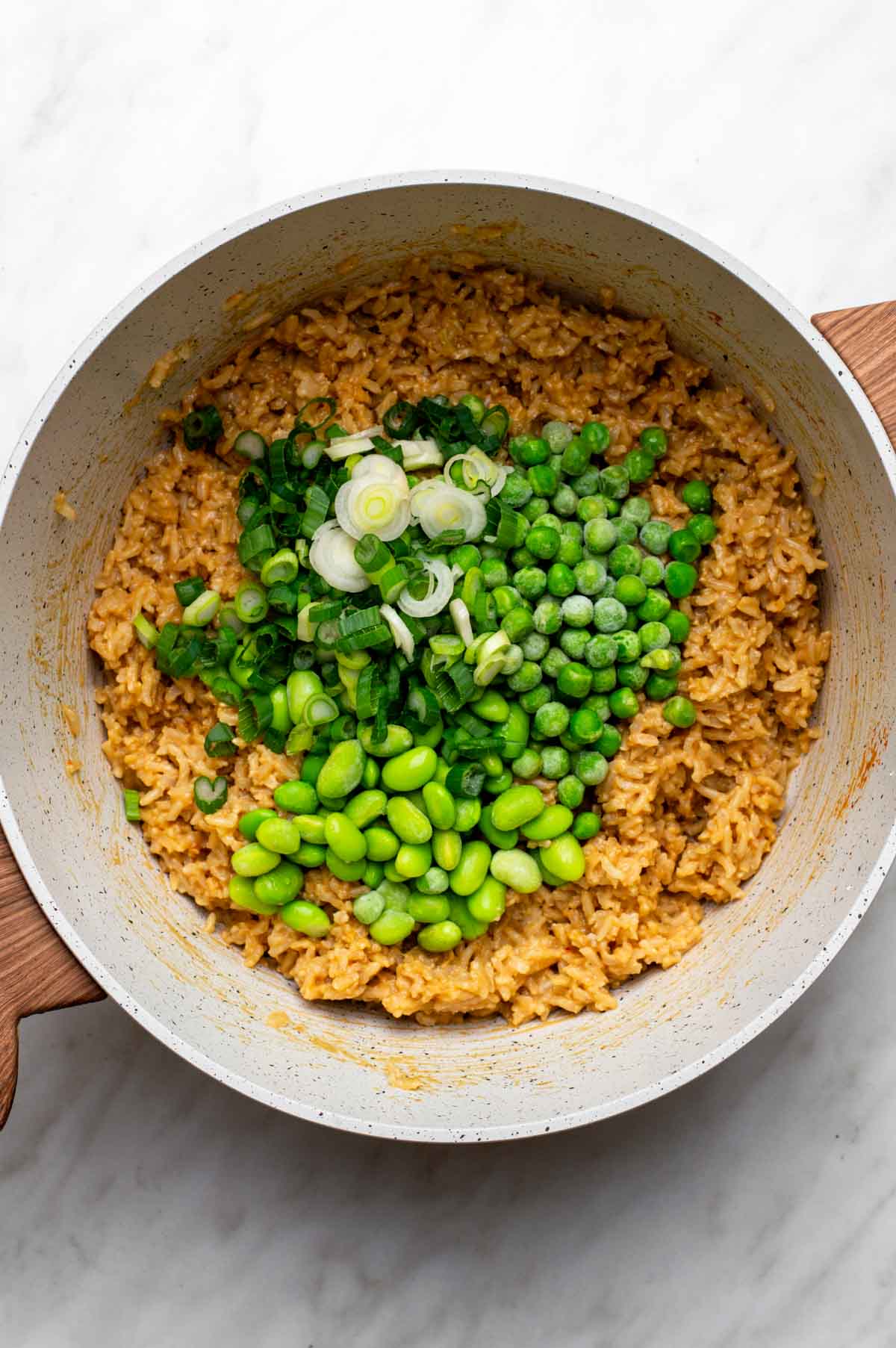 Peanut butter rice with peas and green onions on top.
