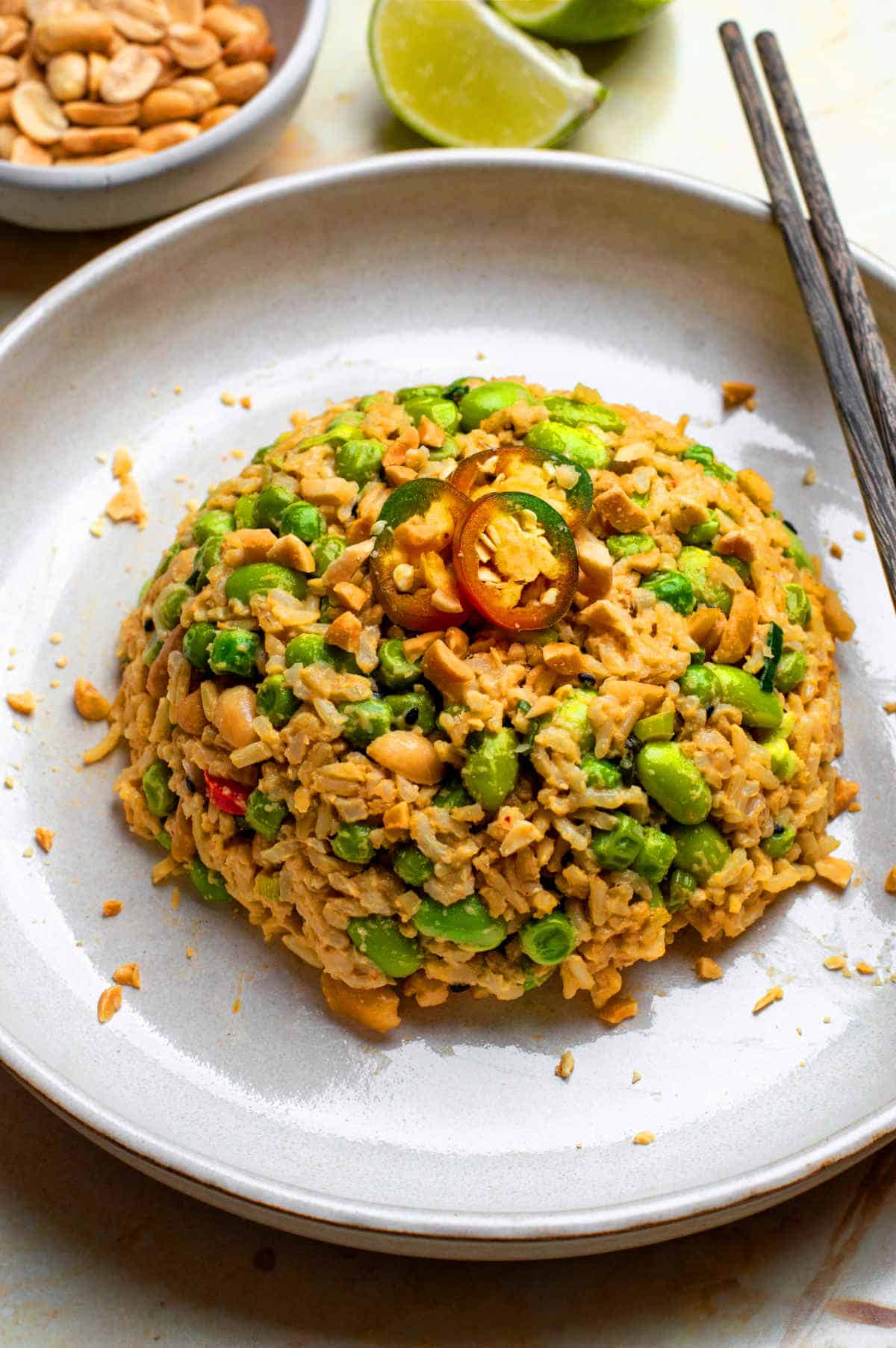 A plate of peanut butter rice with chopsticks placed next to it.