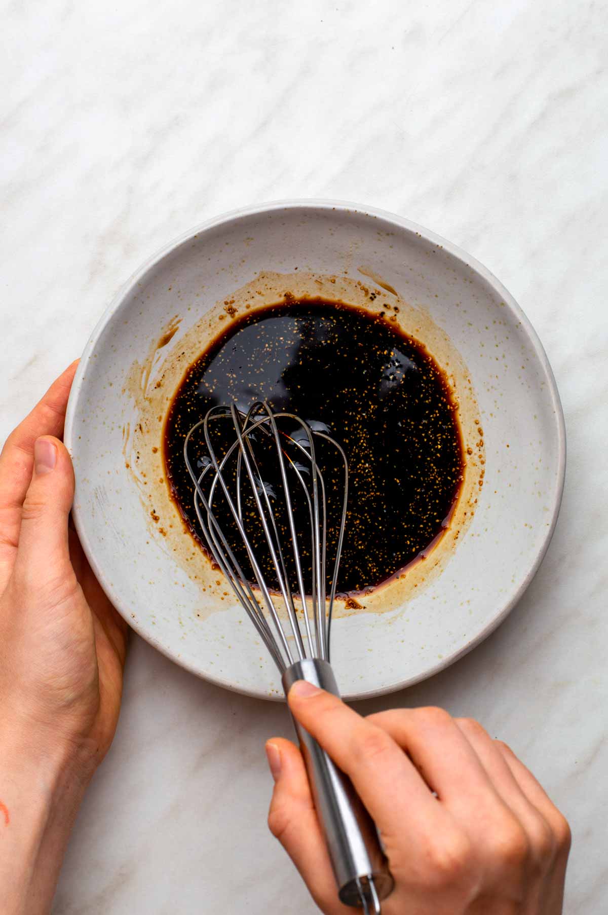 A small bowl of marinade made with soy sauce, maple syrup, and garlic powder.