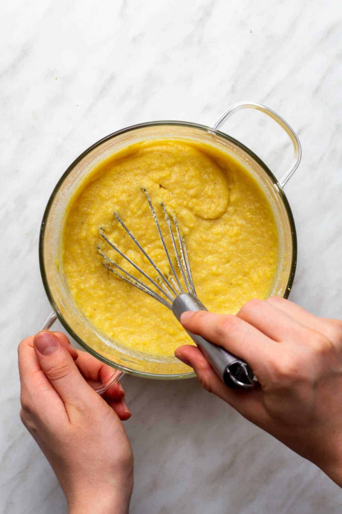Medium saucepan with water or broth and milk boiling, as dry polenta is slowly whisked in with salt.