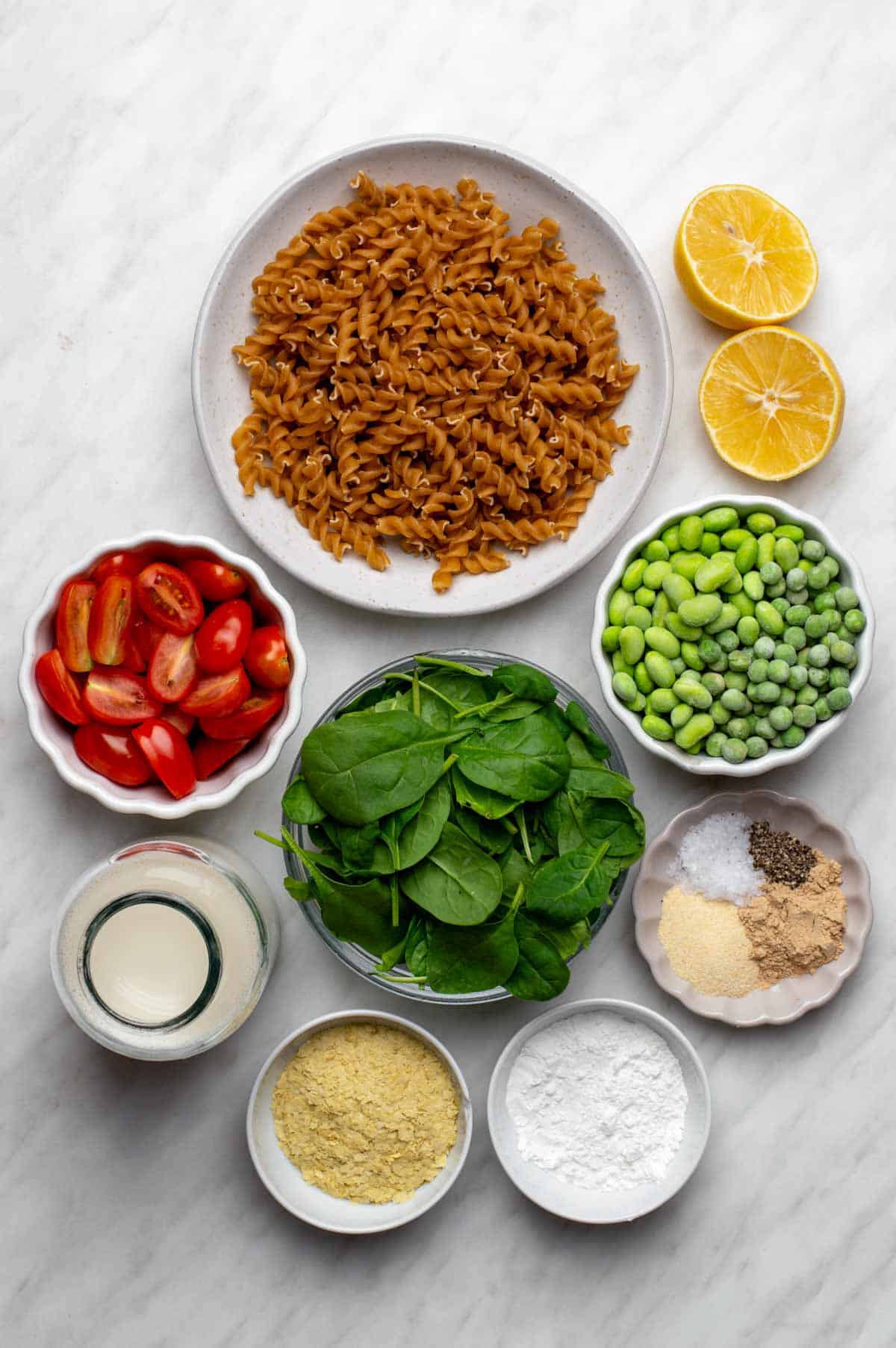Ingredients for creamy veggie pasta arranged on a table.