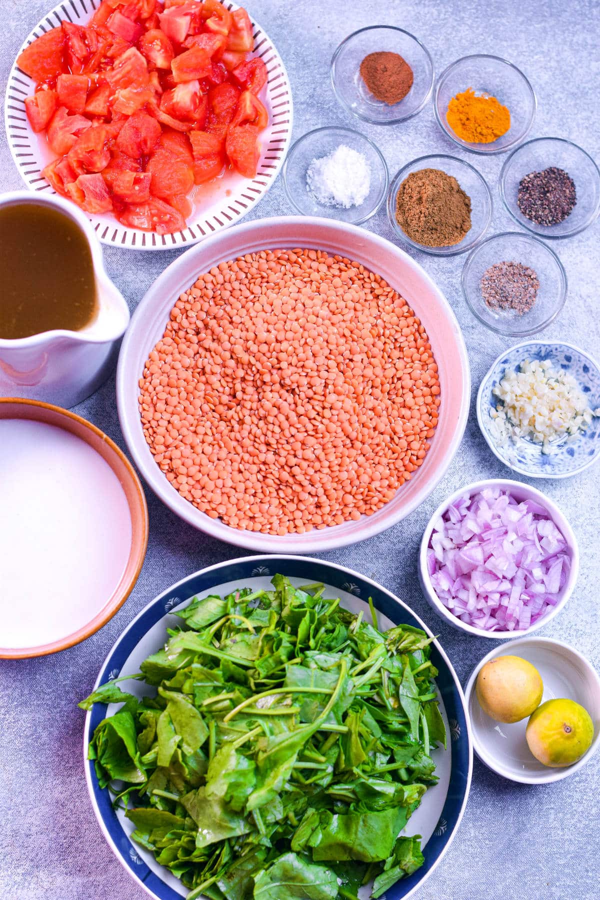 Ingredients for red lentil and spinach soup arranged on a table.
