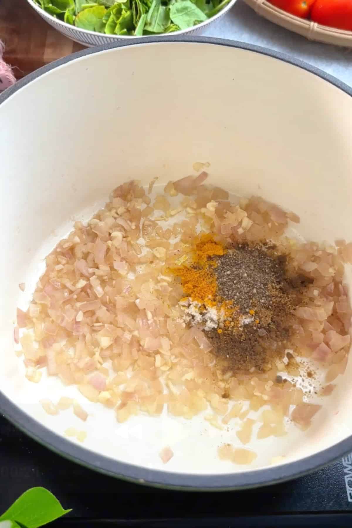 Cooking onions and garlic in a pot with a splash of water.