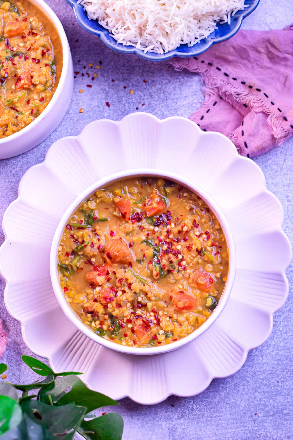A bowl of hearty red lentil and spinach soup with a rich, golden-orange color.