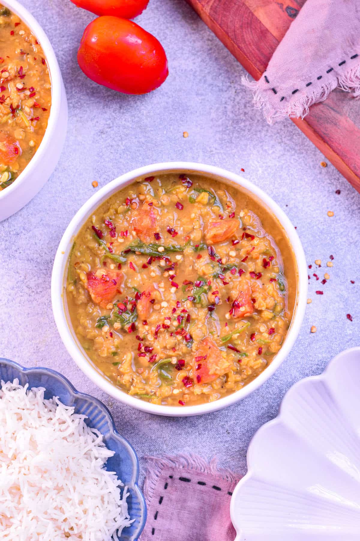 A bowl of hearty red lentil and spinach soup with a rich, golden-orange color.