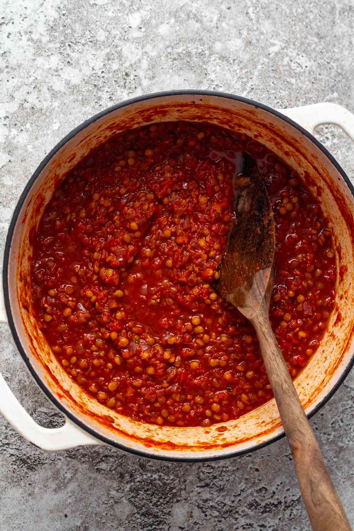 Simmering lentils with wine, tomatoes, and water, seasoned with salt and date syrup.