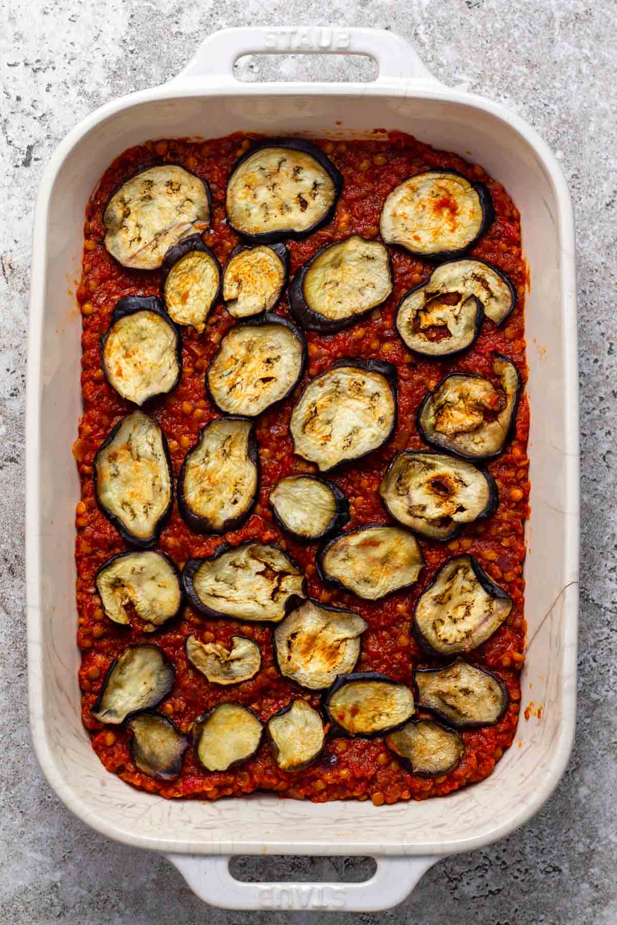 Tomato lentil spread and the roasted vegetables on top in a baking dish.
